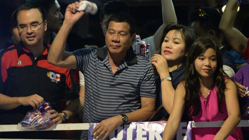 Philippine presidential candidate Rodrigo Duterte, with his partner Honeylet and daughter Veronica, throws a tee shirt to supporters in the town of Silang, Cavite province, on April 22nd. Photograph: Ted Aljibe/AFP/Getty Images