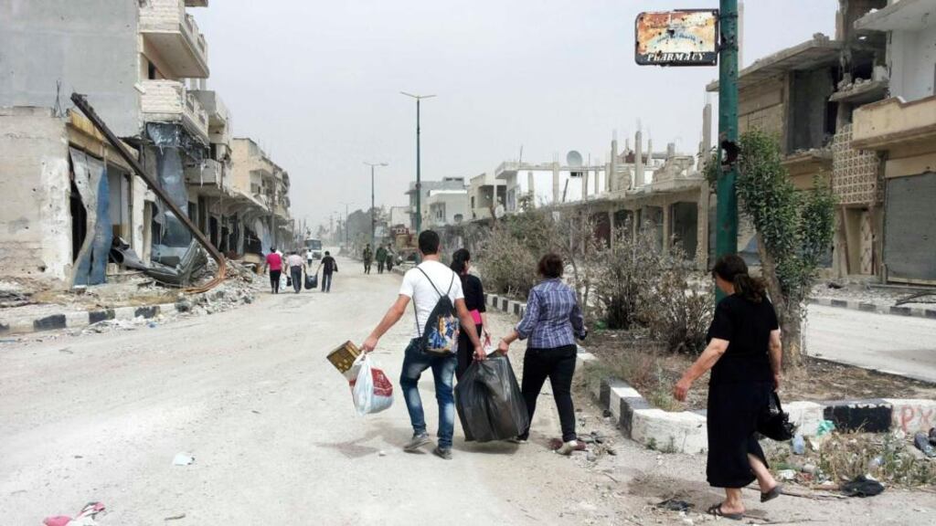 Residents of Qusayr carry bags after visiting their houses to collect belongings. Photograph: Reuters/Rami Bleibel