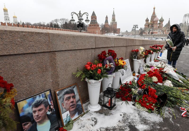 A woman lays flowers at the site where Russian opposition politician Boris Nemtsov was assassinated in 2015 on a bridge in front of the Kremlin. Photograph: Sergei Ilnitsky/EPA-EFE