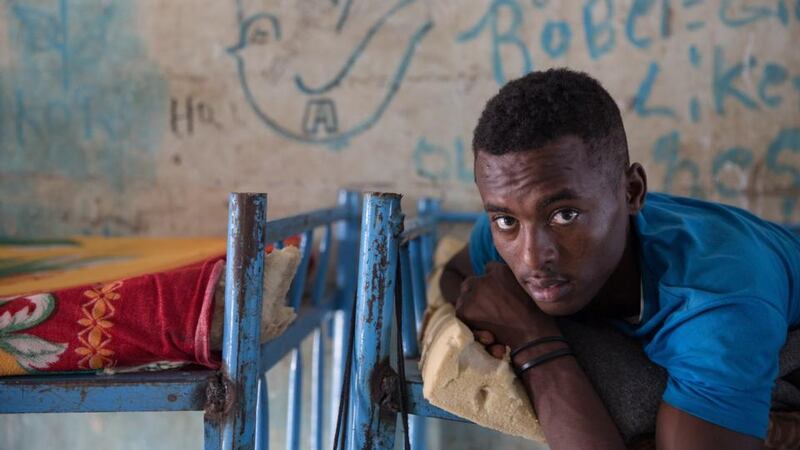 An Eritrean teenager sits on his bed in the unaccompanied minors section of Shagarab refugee camp, eastern Sudan. Photograph: Sally Hayden
