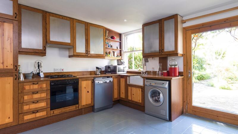 The kitchen has a fashionable grey-tiled floor and built-in units
