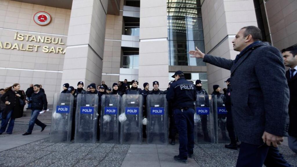 A plainclothes police officer reacts as riot police stand guard in front of the courthouse in Istanbul. Photograph: Osman Orsal/Reuters.