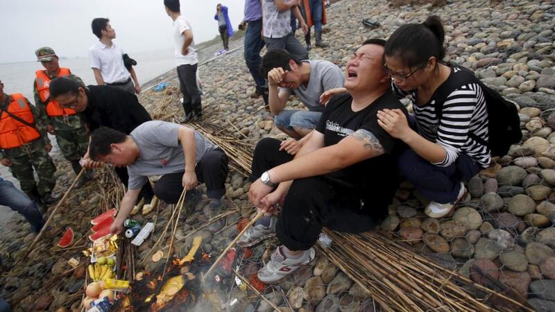 Family members of victims burn incense at during a commemoration ceremony. Photograph: Reuters/Chen Zhuo/Yangzi River Daily