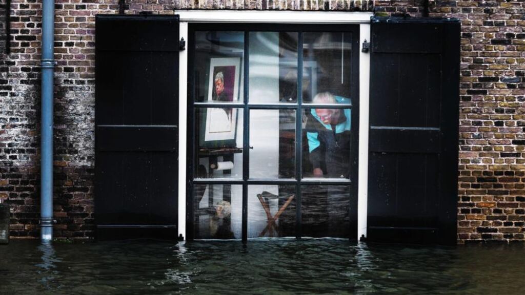 A resident inspects his house in the center of Dordrecht, The Netherlands, today after some areas in the low-lying historic center of the city were flooded. Photograph: EPA