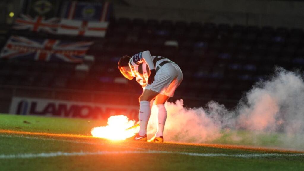 Flares are thrown onto the pitch at Windsor park in Belfast. Photograph: Pacemaker Press