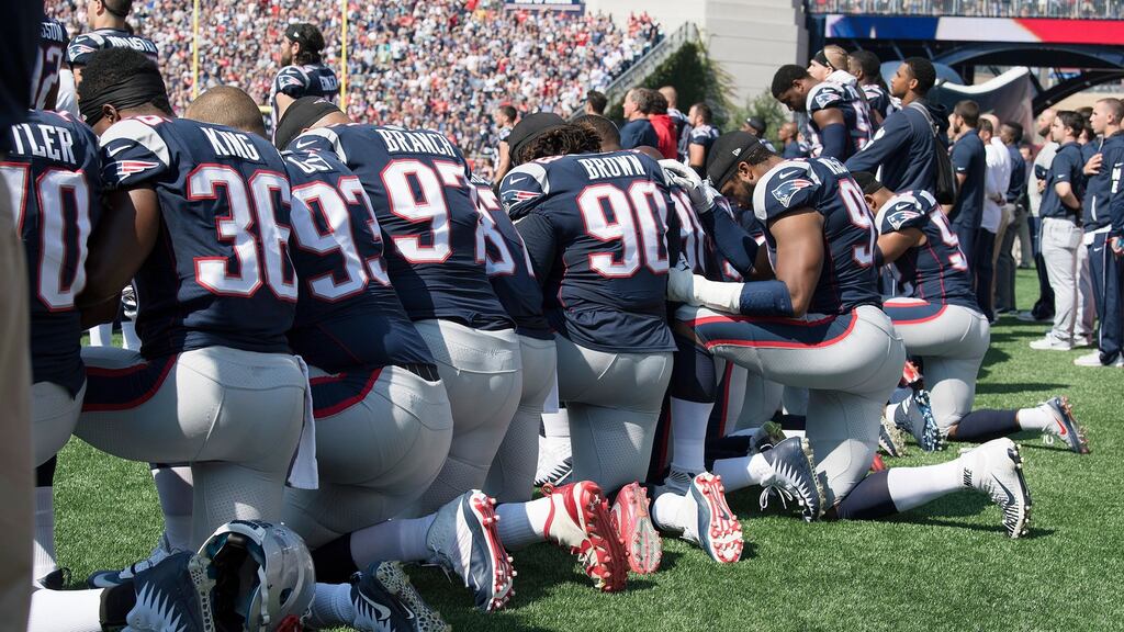 New England Patriots players hold hands and kneel during the national anthem prior to their match against the Houston Texans. Photograph: PA