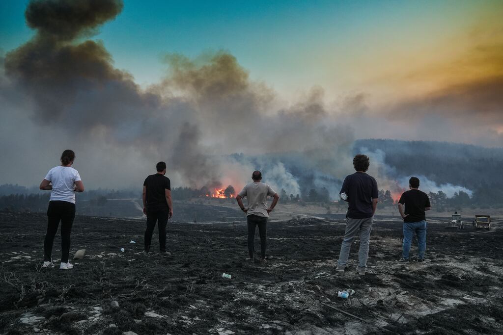 People watch as firefighters respond to wildfires that broke out in a grassy area in Kizilcahamam district of Ankara, Turkey, last August. Photograph: Guven Yilmaz/Anadolu via Getty