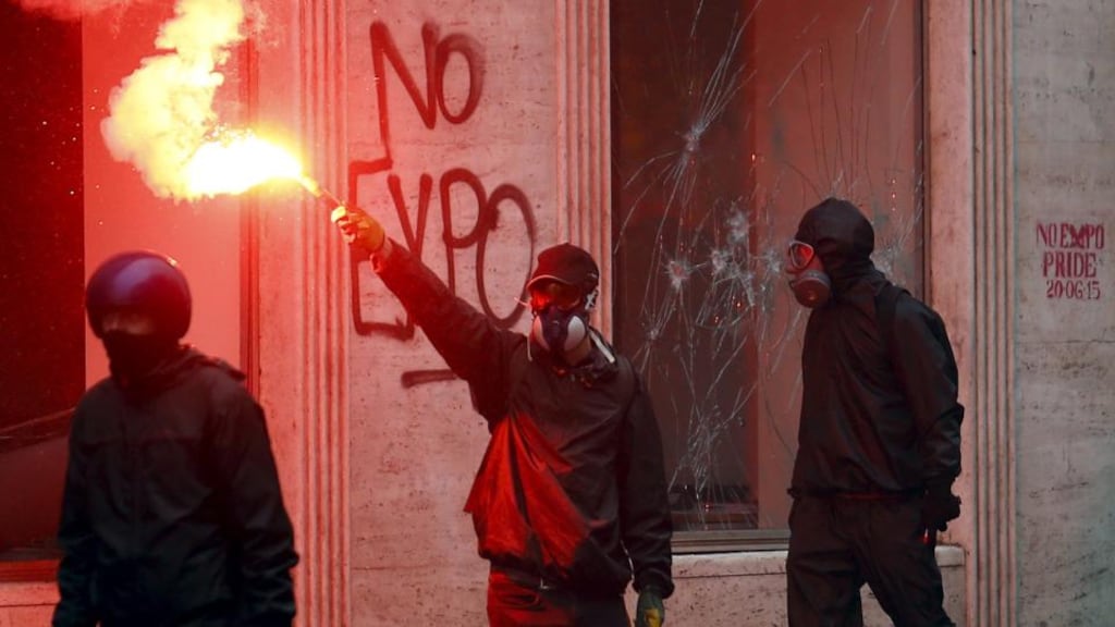 A protester against the Milan Expo holds a flare. Italian police clashed with demonstrators in Milan’s city centre at the start of the global food fair. Photograph: Stefano Rellandini/Reuters