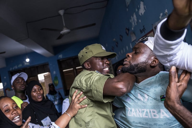 A police officer stops a man accused by electoral officials of attempting to taint the voting process at a polling station in Stone Town, Tanzania, during the country's presidential elections. Photograph: Marco Longari/AFP via Getty Images
