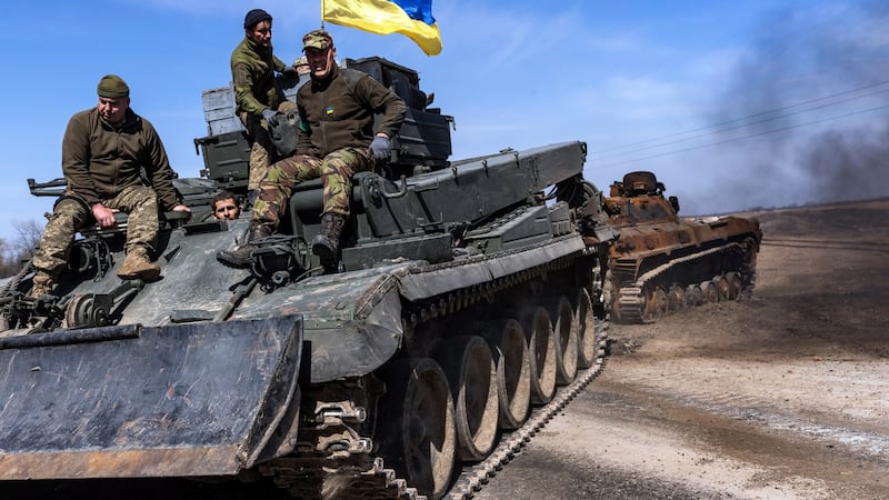Ukrainian soldiers tow a damaged Russian tank from a field near the village of Lypivka, west of Kyiv. Photograph: David Guttenfelder/The New York Times