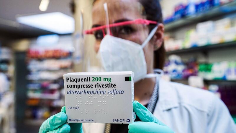 A pharmacist in Turin with a pack of Pasquenil, the new drug based on hydroxychloroquine. Photograph: Tuno Romano/EPA