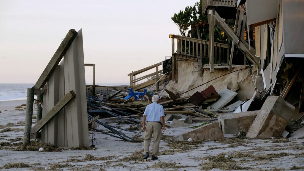 A man assesses the damage to a house at Ponte Vedra Beach in Florida after Hurricane Matthew passed through. Photograph: Charlie Riedel/AP