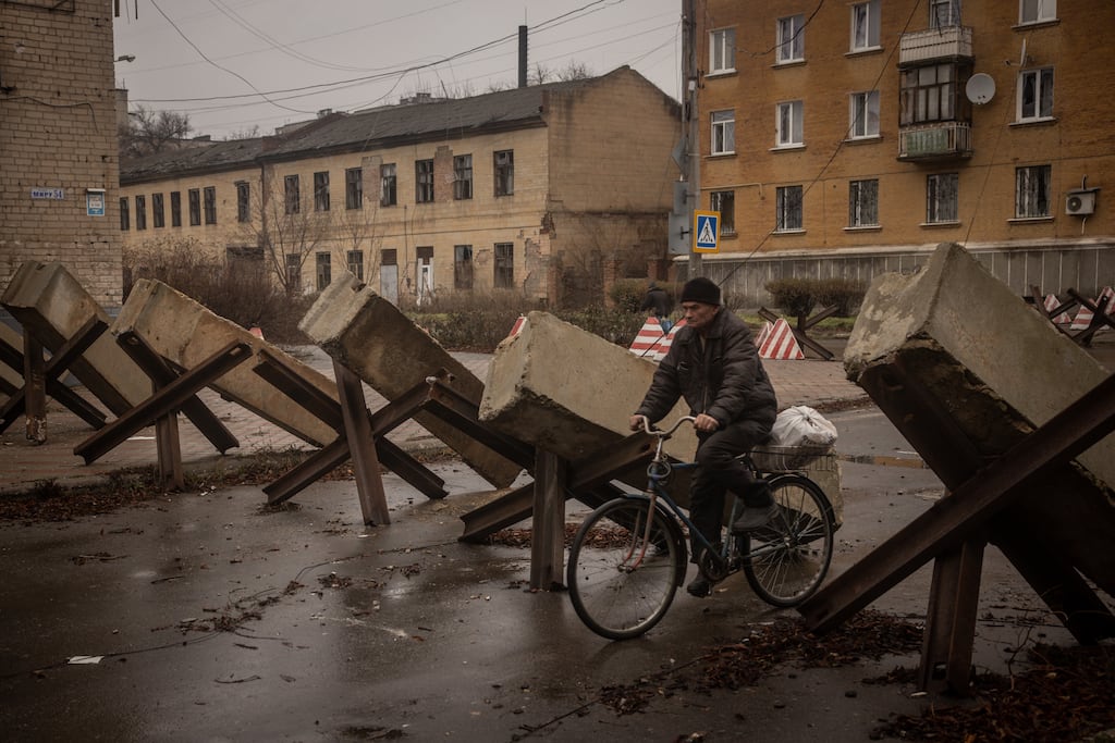 A resident rides his bike through street barricades in Bakhmut, Ukraine, where fierce frontline fighting is taking place. Photograph: Chris McGrath/Getty Images
