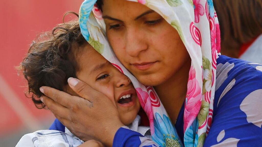 A Syrian Kurdish refugee woman and her child wait after crossing the Turkish-Syrian border near the southeastern town of Suruc in Sanliurfa province today. Photograph: Murad Sezer/Reuters