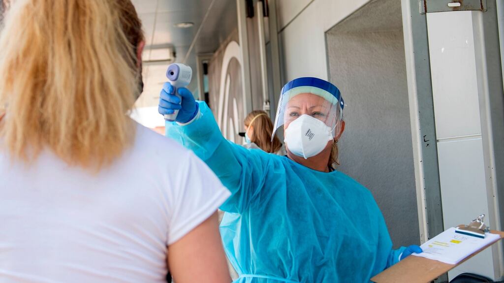 A health worker takes a patient’s temperature at St. John’s Well Child and Family Centre in Los Angeles, California. Photograph: Valerie Macon/AFP via Getty Images