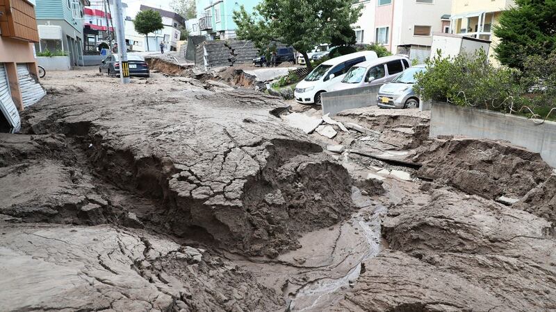 Cars are parked along a road damaged by an earthquake in Sapporo, Hokkaido prefecture. Photograph: Jiji Press/AFP/Getty Images