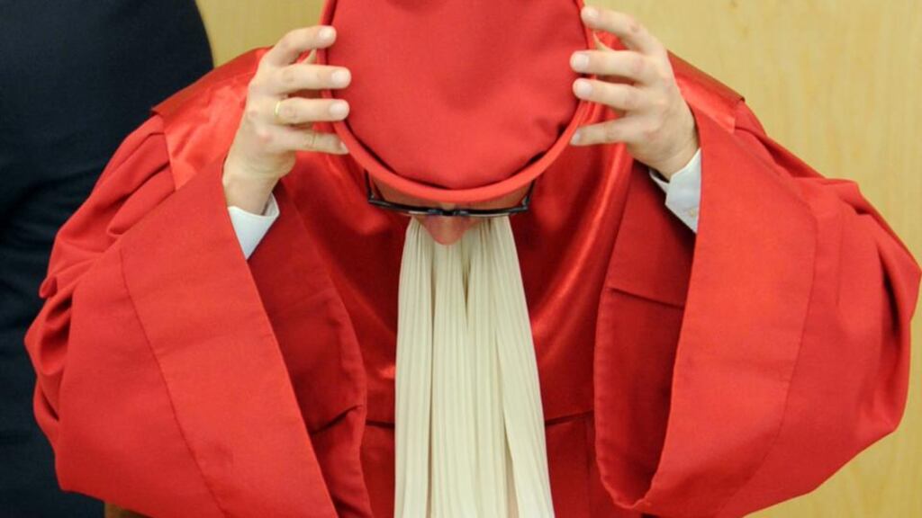 Andreas Vosskuhle, presiding judge of the Second Senate of the Federal Constitutional Court of Germany, puts on his cap after the ESM verdict in Karlsruhe, Germany. Photograph: Uli Deck/EPA