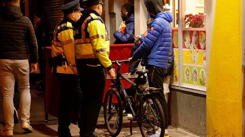 Garda Leigh Higgins and Garda Michael Moore stop and search an individual on Aston Quay, Dublin. Photograph: Alan Betson
