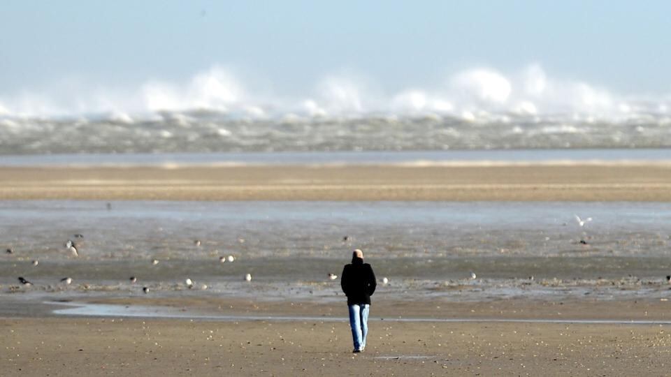 A walker looks at large waves from the beach at Sandymount in Dublin. Photograph: Alan Betson/The Irish Times