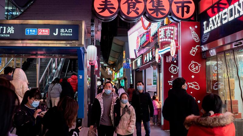 People walk on a street in Wuhan on Sunday, J the eve of the first anniversary of China confirming its first death from the Covid-19 coronavirus. Photograph: Nicolas Asfouri/AFP via Getty Images