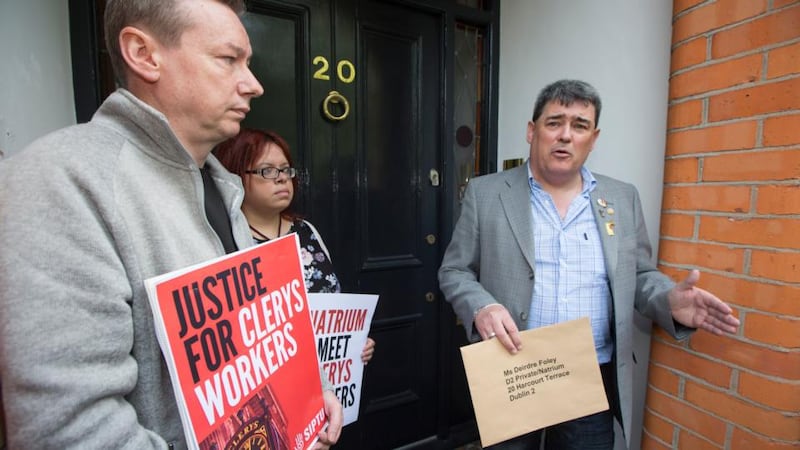 Gerry Markey, a shop steward who has worked for 34 years at Clerys, delivers a letter to Deirdre Foley of Natrium, the new owners of Clerys, with other former staff outside the Natrium offices on Harcourt Terrace on Friday. Photograph: Fergal Phillips