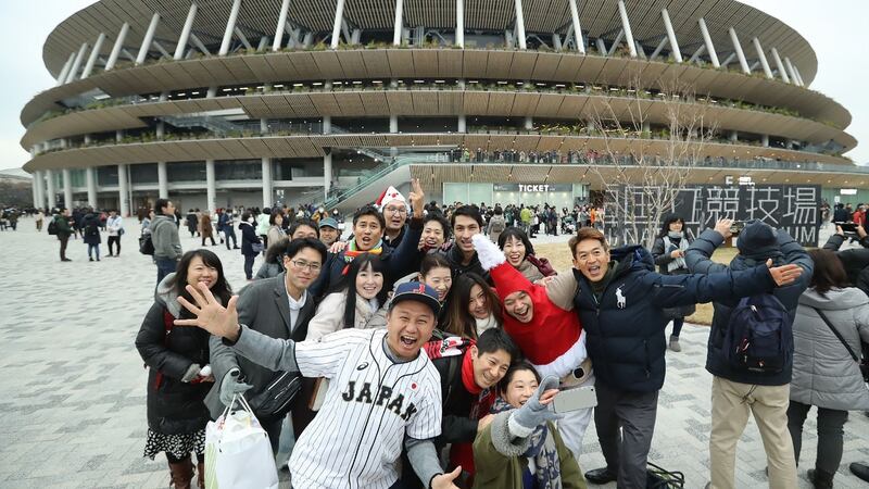 People pose outside the new National Stadium in Tokyo on Saturday December 21st. The stadium is the main venue for the upcoming Tokyo 2020 Olympic Games in July. Photograph: STR/Jiji Press/AFP via Getty Images