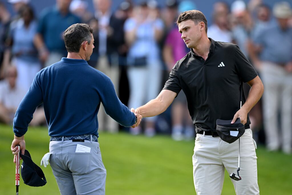 Rory McIlroy of Northern Ireland and Ludvig Aberg of Sweden shake hands on the 18th green during Day One of the BMW PGA Championship at Wentworth Golf Club on September 14th in Virginia Water, England. Photograph: Ross Kinnaird/Getty Images