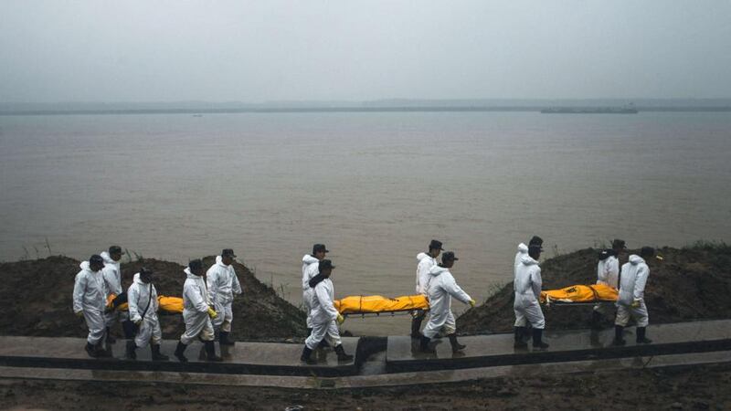 Rescuers carrying the bodies of the victims of the capsized Chinese cruise ship walking on the riverbank in Jianli, central China’s Hubei province. Photograph: AFP/Getty Images