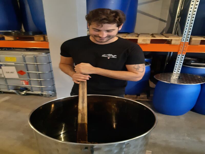 Romain Gauthier stirring genepi plants steeping in alcohol at Aravis Distillery