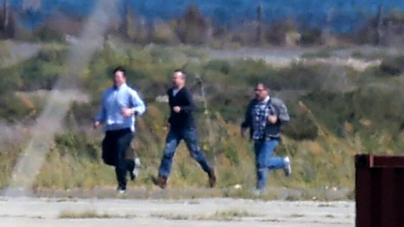 Passengers from a hijacked EgyptAir flight which was diverted to Cyprus run on the tarmac after leaving the plane as the hijacker surrendered to security forces on Tuesday. Photograph: George Michael/AFP/Getty Images