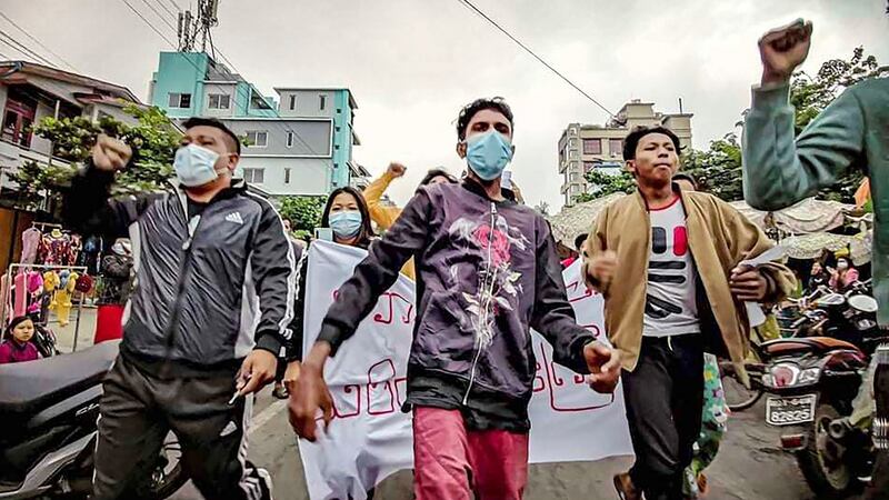 Protesters march through the streets during an anti-government demonstration in Mandalay, Myanmar, on Tuesday. A small group of protesters held a rally against the military government, a day after a court sentenced ousted leader Aung San Suu Kyi to four years in prison. Photograph: AP Photo