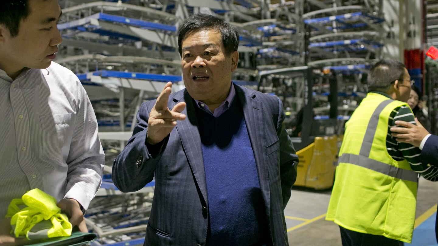 Cho Tak Wong (centre) chairman, and  Charles Cheng, left, translating for Mr. Wong, during a tour the plant at Fuyao Glass in Moraine, Ohio. Photograph: Andrew Spear for The Washington Post/Getty Images