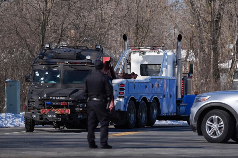 A police vehicle with bullet marks is towed away. Photograph: Abbie Parr/AP