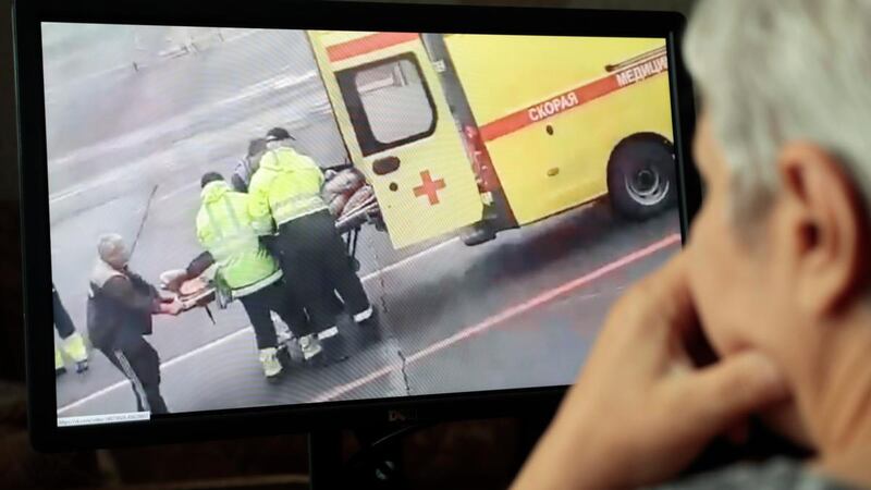 A person in Moscow watches a video on social media showing Alexei Navalny being carried on a stretcher into an ambulance. Photograph: Sergei Chirikov/EPA