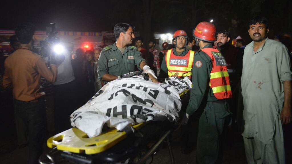 Pakistani rescuers  move a body from the  bomb blast site in a Lahore public park.  Photograph:   Arif Ali/AFP/Getty Images