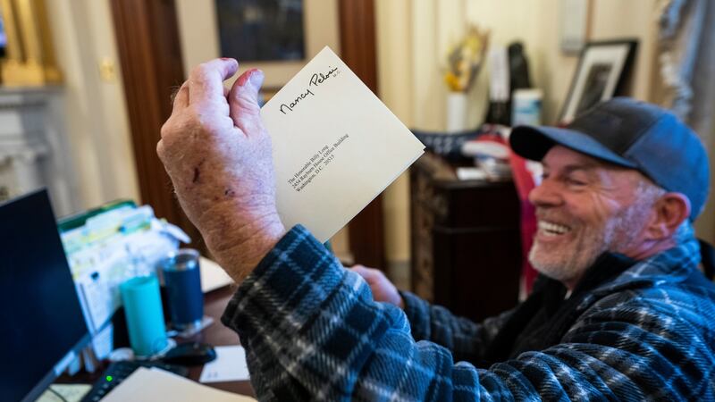 A Trump supporter sits on the desk of House speaker Nancy Pelosi. Photograph: Jim Lo Scalzo/EPA