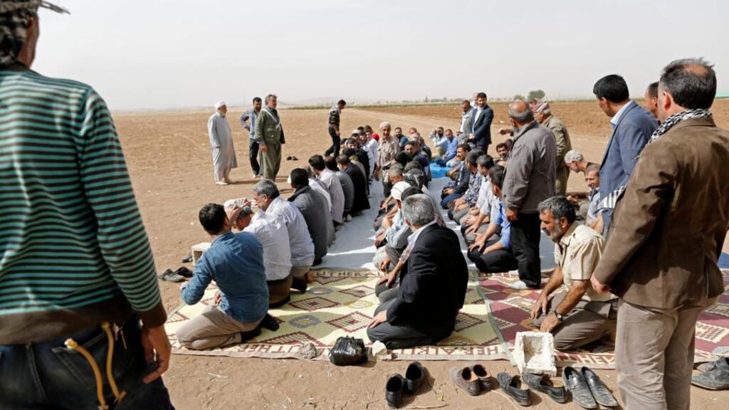 Muslims perform a prayer today near the Turkish border with Syria for Kurdish fighters killed in Kobani while fighting against Islamic State. Photograph: Tolga Bozoglu/EPA
