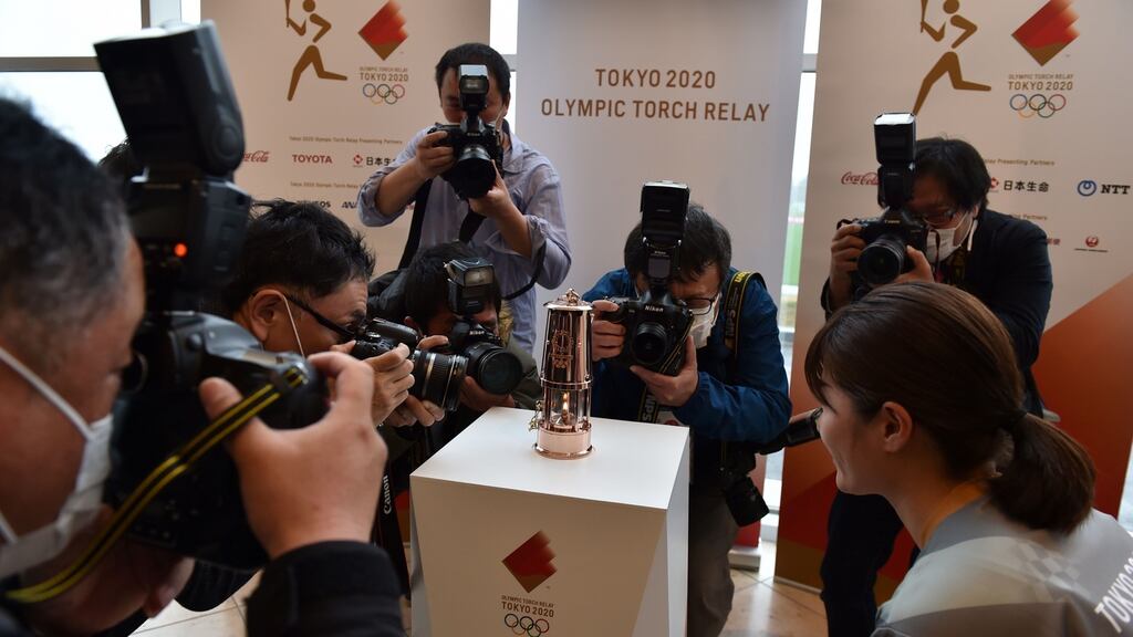 Photographers surround the Olympic flame after the handover ceremony of the lantern containing the Olympic flame from Tokyo 2020 to Fukushima. Photograph: Kazuhiro Nogi/ AFP via Getty