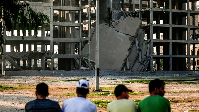 Palestinian youths look at a building that was damaged by an Israeli air strike in Gaza City on July 14, 2018. Photograph: AFP/Getty Images