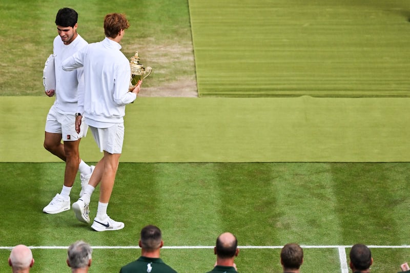 Jannik Sinner and Carlos Alcaraz greet each other with their trophies during the presentation ceremony on Centre Court at Wimbledon. Photograph: Glyn Kirk/AFP via Getty Images