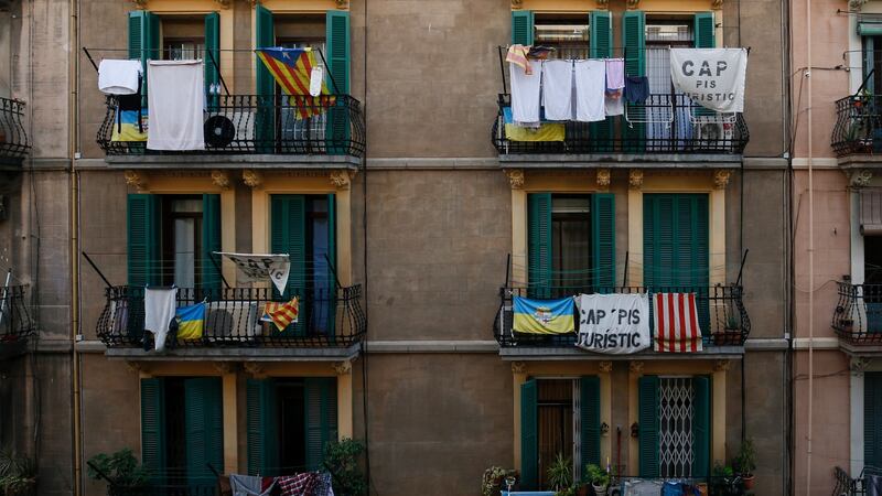 Banners reading “No tourist flats” hang from a balcony to protest against holiday rental apartments for tourists in Barcelona’s neighborhood. Photograph: Pau Barrena/AFP via Getty Images