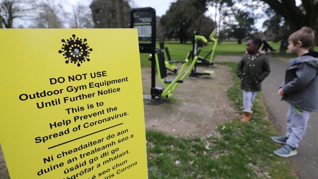 Oisín Carson (5) and Isabella Fayeun (6) standing near a Covid-19 notice near an outdoor gym that has been closed due to coronavirus restrictions in Athy, County Kildare. Photograph: Niall Carson/PA