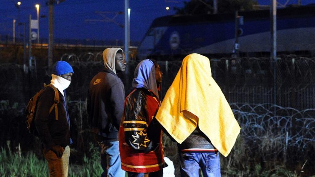 Migrants walk near the Eurotunnel rail terminal in Coquelles near the northern French port of Calais. The European Union is offering funds and aid to help France cope with growing numbers. Photograph: Francois Lo Presti/AFP/Getty Images.