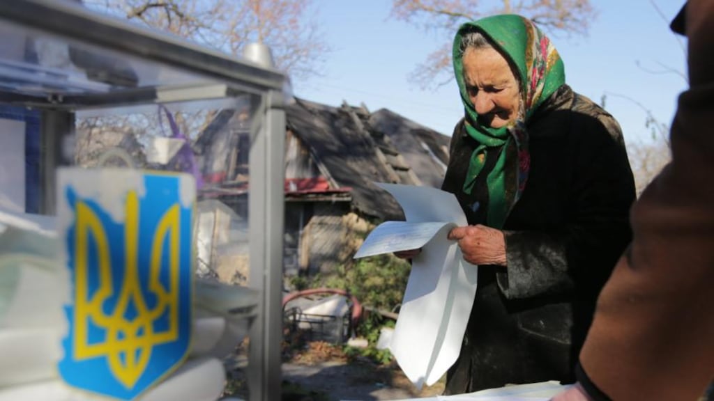 An elderly Ukrainian woman reads her ballot papers during the elections, in the Krenichi village, about 40km from Kiev. Photograph: Tatyana Zenkovich