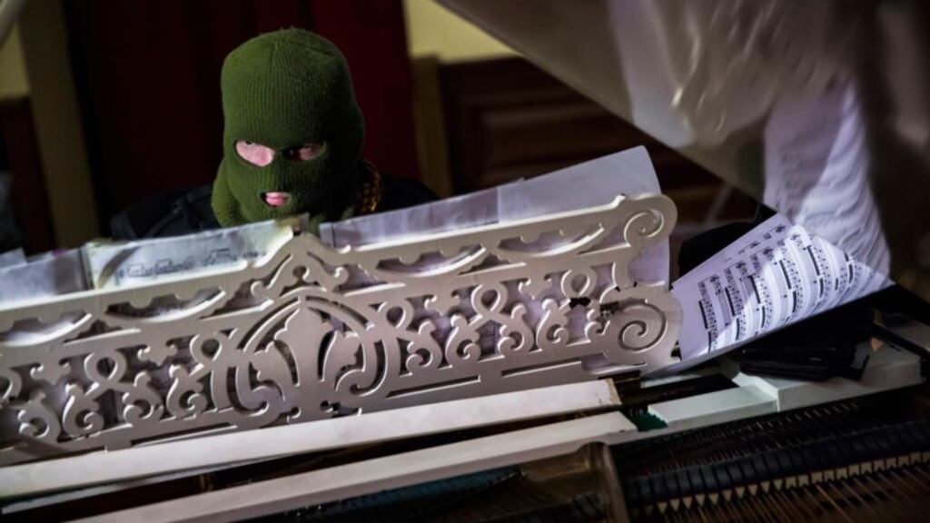 A masked man plays the grand piano to an audience of anti-government protesters in Kiev City Hall, occupied by opposition forces, yesterday. Photograph: Thomas Peter/Reuters