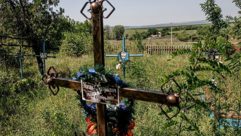 The graveyard in Dobrusa, Moldova is slowly receding into an undergrowth of nettles and bramble, grass flowers and cow parsley. Photograph: Laetitia Vancon/The New York Times