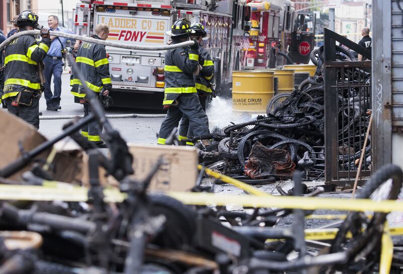 Firefighters put water on still-burning batteries after a fire at an e-bike store that killed four people in New York in June. Photograph: Justin Lane/EPA