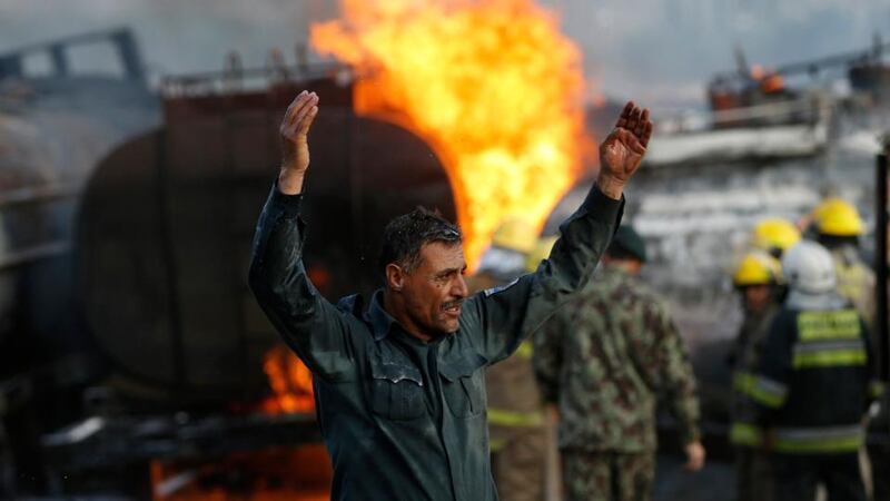A policeman reacts at the site of burning fuel trucks. Photograph: Mohammad Ismail/Reuters
