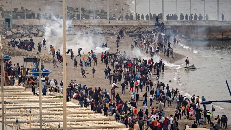 Tear gas fumes fill the air as Spanish security forces watch Moroccan migrants near a border fence in the northern town of Fnideq in an attempt to cross the border into Ceuta. Photograph: Fadel Senna/AFP via Getty Images