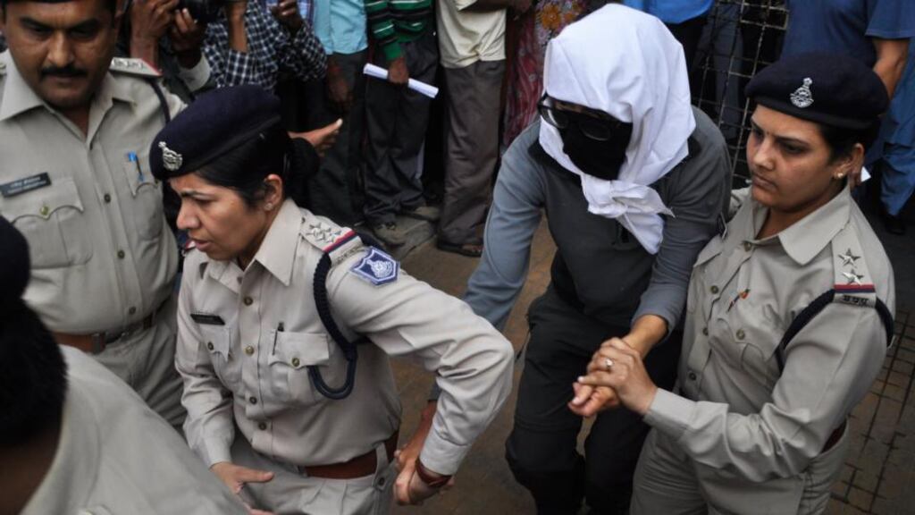A Swiss woman with her face covered is taken to a hospital by police for her medical examination at Gwalior in the central Indian state of Madhya Pradesh yesterday.  Six men are being held in connection with the attack, police said today. Photograph: Reuters